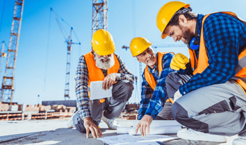 Construction workers looking at blueprints